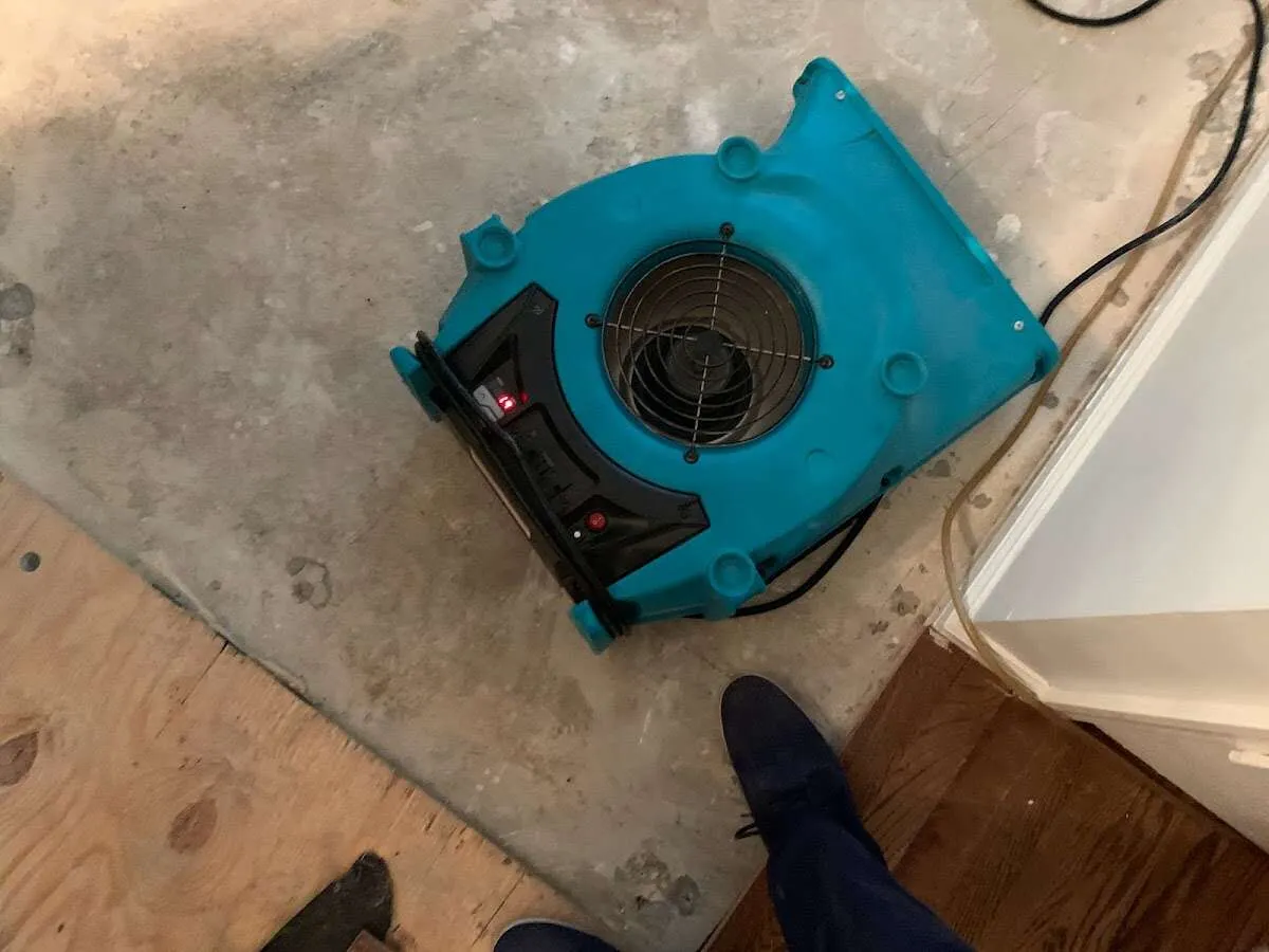 Air mover drying subfloor during Commercial Water Damage Restoration in Nitro